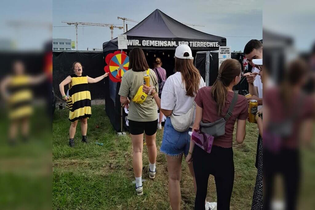 PETA-Streetteam-Mitarbeiterin motiviert Festivalbesuchende auf eine Wurfscheibe zu werfen.