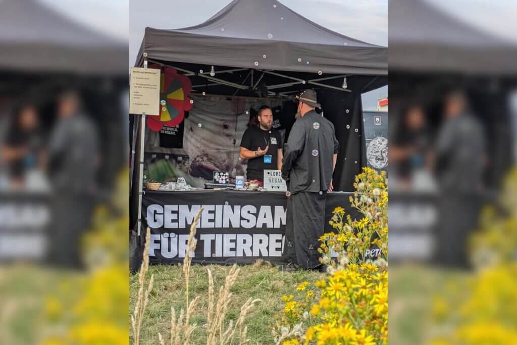 PETA Streetteam mit Stand auf dem Mera Luna Festival redet mit einem Interessenten.